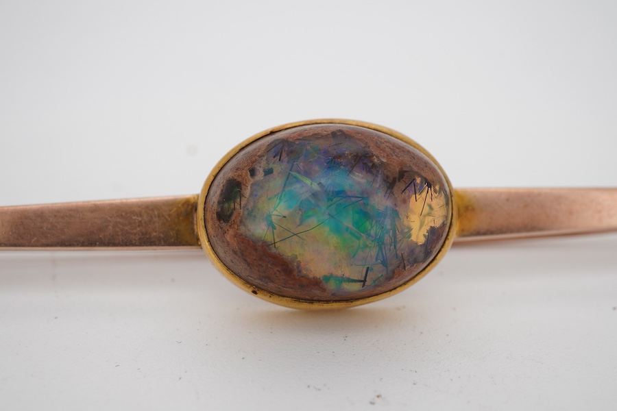 A boulder opal brooch, early 20th century, the bar brooch set with a cabochon boulder opal measuring approximately 16.9 x 12 x 9.5mm, mounted in gold, gross weight 8 grams